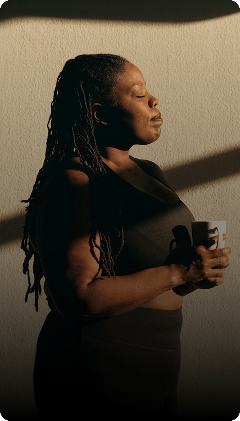 Woman holding a mug against a plain background