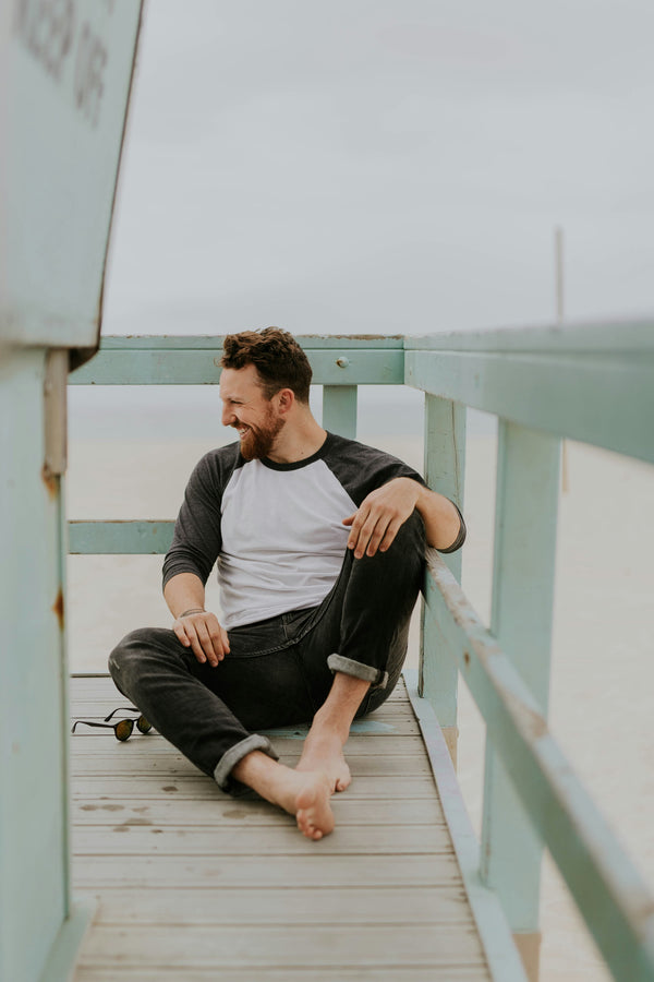 Man sitting on a wooden deck with green railings