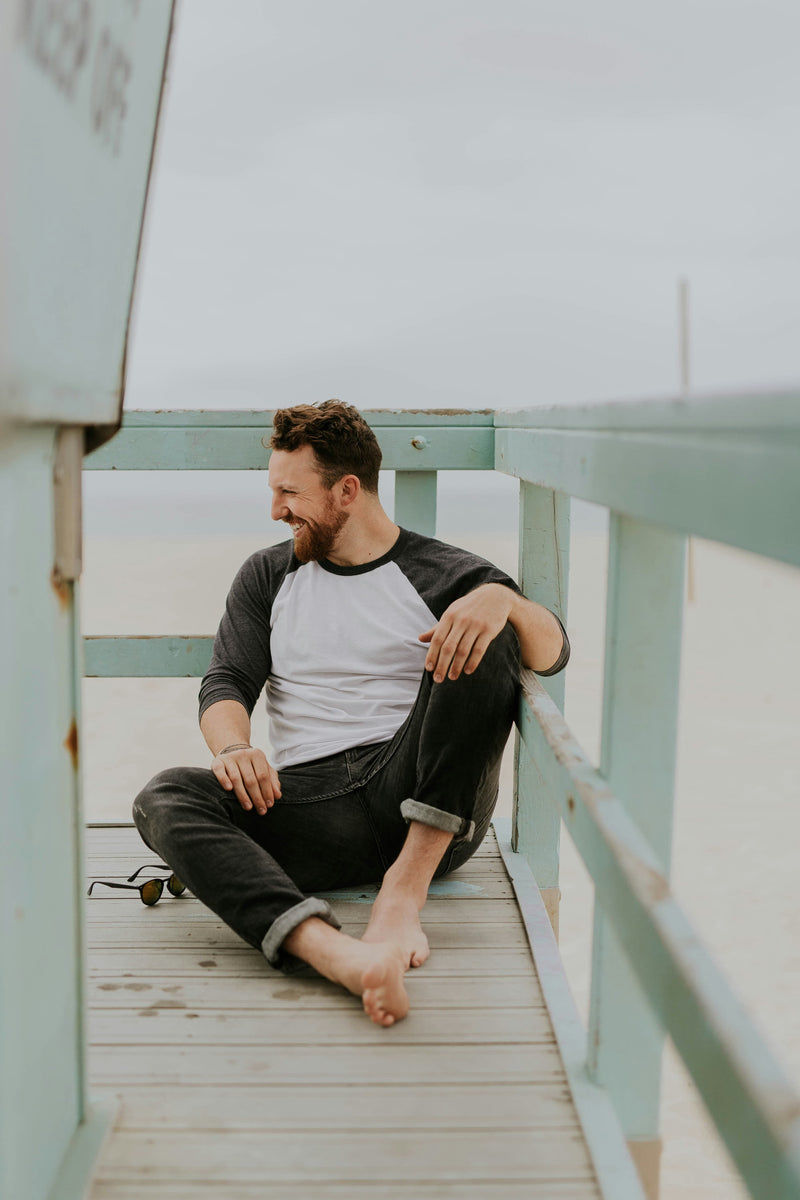 Man sitting on a wooden deck with green railings