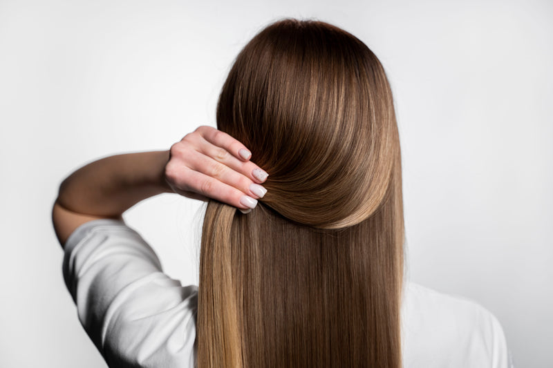 Person with long, straight brown hair against a white background